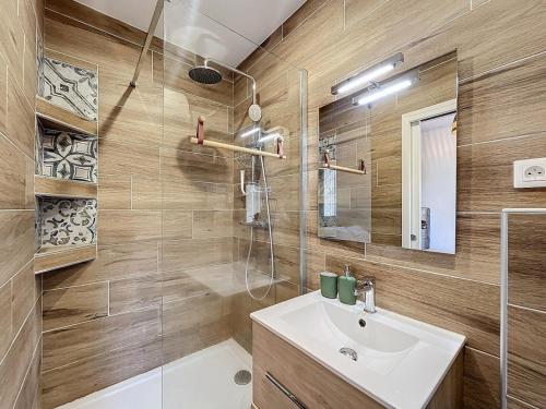 une salle de bain avec un lavabo et une douche en verre dans l'établissement Cozy garden apartment - Caen, à Caen