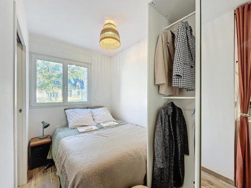 une petite chambre avec un lit et une fenêtre dans l'établissement Cozy garden apartment - Caen, à Caen