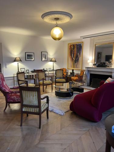 a living room with chairs and a couch and a fireplace at Gîte en Normandie avec piscine in Rugles