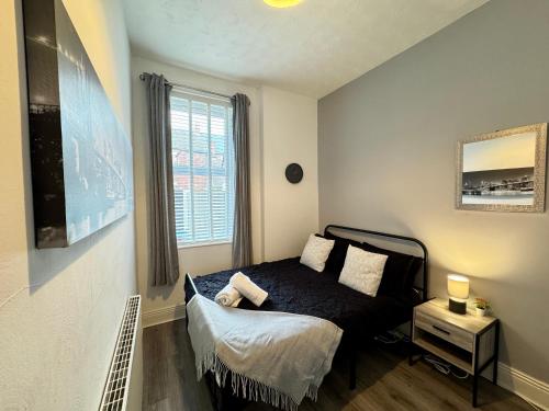 a small bedroom with a bed and a window at Belford Apartment 1, Close to Tynemouth in Tynemouth