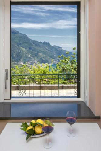 a window with a plate of fruit and two wine glasses at Ravello Views Apartment in Ravello
