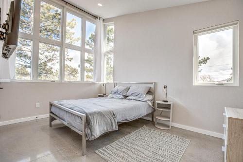 a bedroom with a bed and two windows at Walk to Trail Lookout Landing Newly Built Home! in Golden