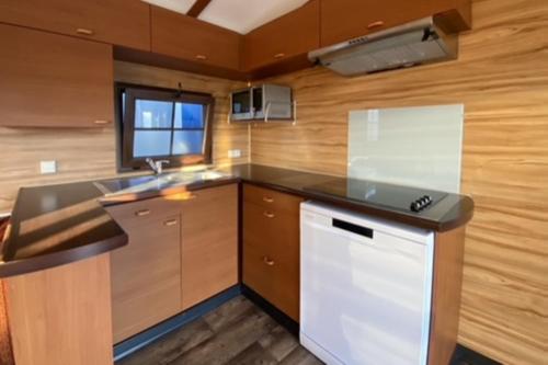 une cuisine avec un évier et un plan de travail dans l'établissement Pôle Européen du Cheval - Les Cottages de la Futaie, à Yvré-lʼÉvêque