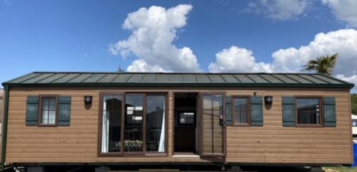 une petite maison avec un toit en tôle sur le dessus dans l'établissement Pôle Européen du Cheval - Les Cottages de la Futaie, à Yvré-lʼÉvêque