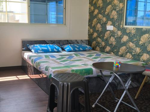 a bed in a room with a small table at Cozy Cottage near Hessarghatta in Bengaluru