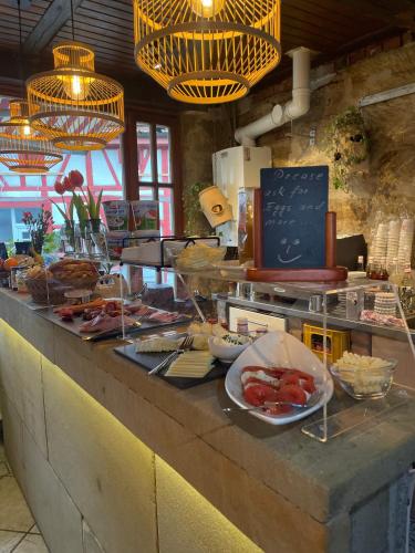 a buffet line with plates of food on a counter at Hotel Scheunenwerk - Nürnberg Nord in Heroldsberg