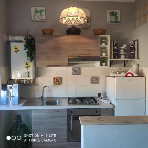 a kitchen with a sink and a white refrigerator at Casa di Ana 2 in Ancona