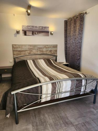 une chambre avec un grand lit avec une tête de lit en bois dans l'établissement Appart Rez de jardin vue mer, à Cavalaire-sur-Mer