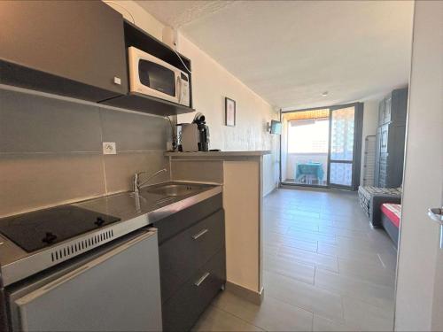 une cuisine avec un évier et un micro-ondes dans l'établissement Studio 3 couchages CAP D'AGDE CT395-050, au Cap d'Agde