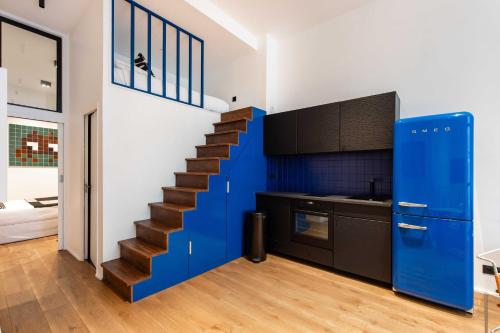 un escalier dans une cuisine avec un mur bleu dans l'établissement Magnificent apartment - 1BR-6P - Sentier, à Paris