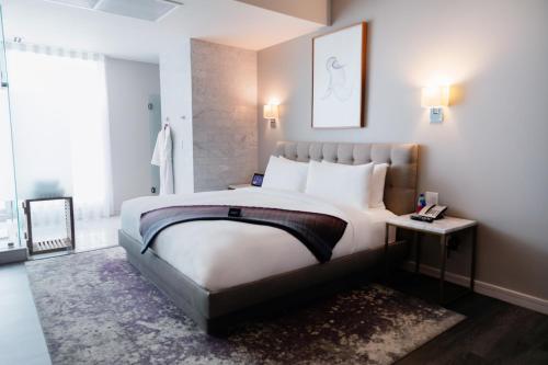 a bedroom with a large white bed and a window at Stanton House El Paso in El Paso
