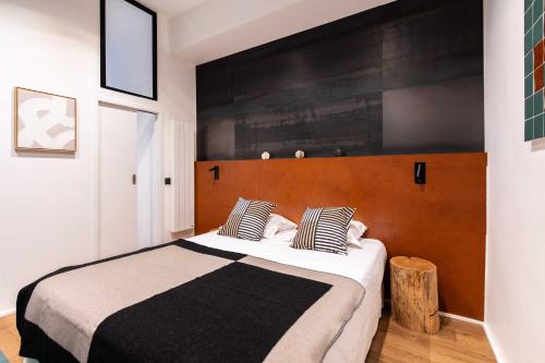 une chambre avec un grand lit avec une tête de lit en bois dans l'établissement Magnificent apartment - 1BR-6P - Sentier, à Paris