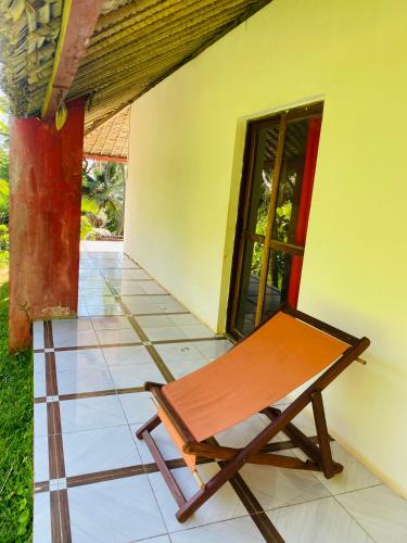 a bench sitting on the porch of a house at Nosy-Borah Holidays in Analabe