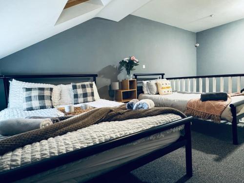 two beds in a room with blue walls at Queens Townhouse - 4 Bedrooms - Sleeps 9 in Whitehaven