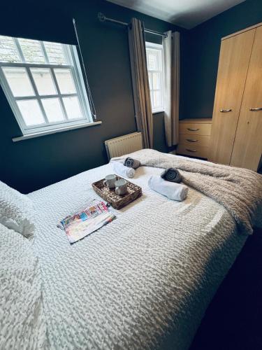 a bedroom with a bed with towels and a tray on it at Queens Townhouse - 4 Bedrooms - Sleeps 9 in Whitehaven