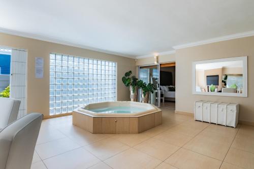 a large room with a bath tub in the middle at Gem with indoor jacuzzi in Cape Town