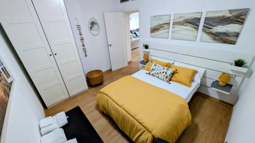 une petite chambre avec un lit avec des draps jaunes dans l'établissement Puerto de la Duquesa Sea Views, à Manilva