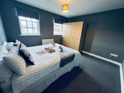 a bedroom with a large bed with blue walls at Queens Townhouse - 4 Bedrooms - Sleeps 9 in Whitehaven