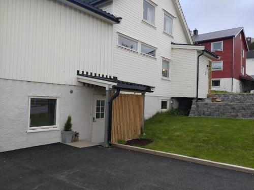 una casa blanca con un garaje al lado de un patio en Arctic Retreat - two separate bedroom apartment, en Tromsø