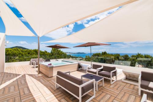 an outdoor patio with a pool and chairs and an umbrella at Hotel Na Taconera in Cala Ratjada