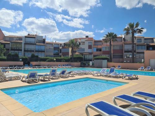 - une piscine avec des chaises longues et des chaises dans l'établissement Studio cabine CAP D'AGDE CT340-411, au Cap d'Agde