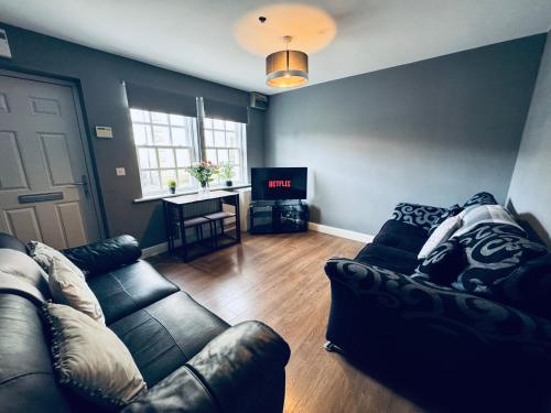 a living room with a couch and a television at Queens Townhouse - 4 Bedrooms - Sleeps 9 in Whitehaven