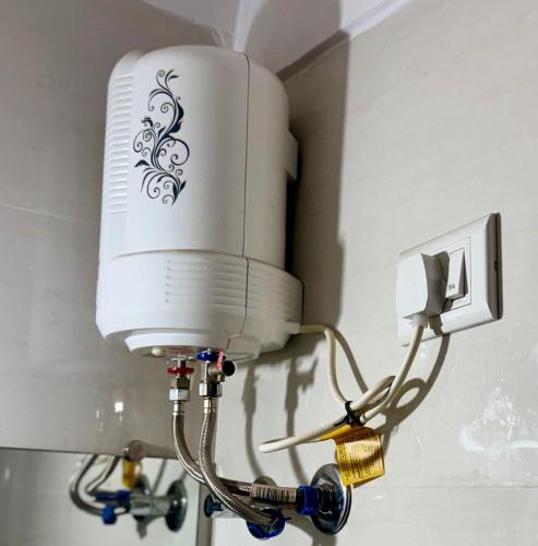 a white light on a wall with a cord plugged into it at Sadanand Home in Navi Mumbai