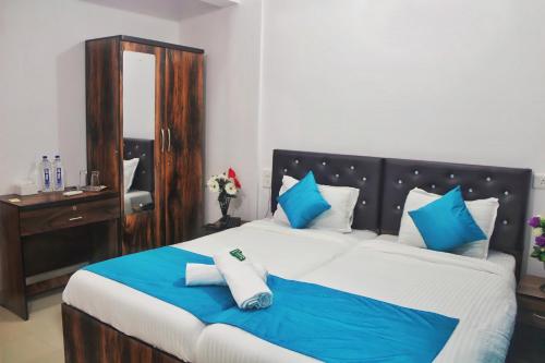 a bedroom with a large bed with blue and white pillows at Sadanand Home in Navi Mumbai
