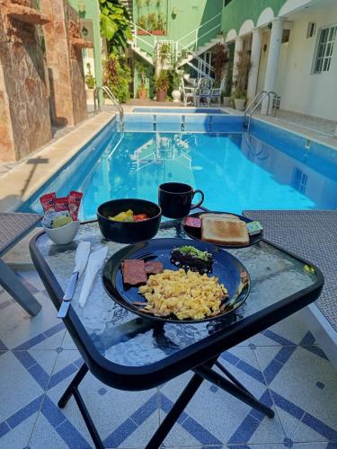 a tray of food on a table next to a pool at Hotel CEO Group in Campeche