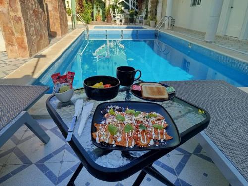 a tray of food on a table next to a pool at Hotel CEO Group in Campeche