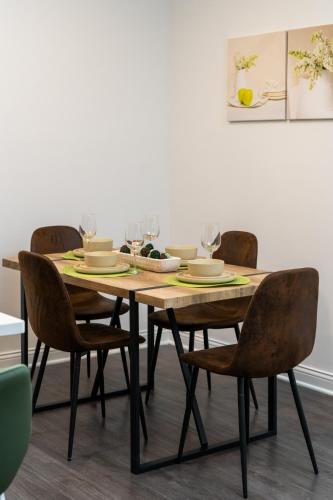 a dining room table with chairs and wine glasses at Golden Sun Spacious 1BR Pond View King Bed WFH Gym in Whitestown
