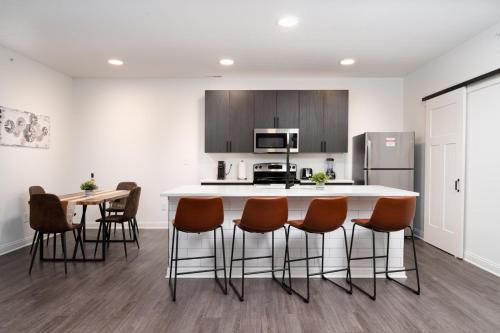 a kitchen with a counter and a table and chairs at Sunrise Glow Spacious 2BR 2BA 2 King Beds Gym WFH in Whitestown