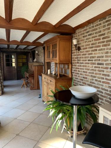 a kitchen with a table and a brick wall at A l'Etang du Trieu in Pecq