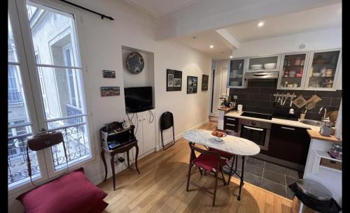 - une cuisine avec une table et une petite table dans une chambre dans l'établissement Bright apartment on Rue Ballu, à Paris