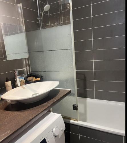 une salle de bain avec un lavabo blanc et une douche dans l'établissement Bright apartment on Rue Ballu, à Paris