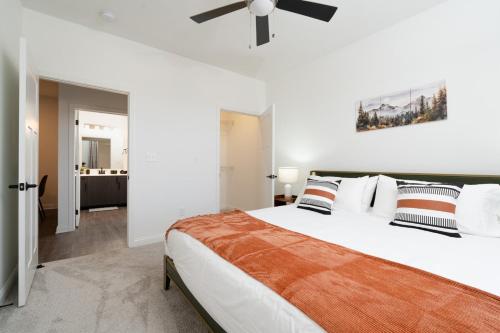 a white bedroom with a large bed and a ceiling fan at Grandeur Unit Royal 103 in Whitestown