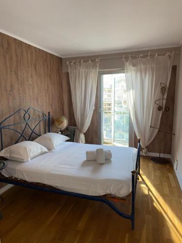 une chambre avec un lit avec des draps blancs et une fenêtre dans l'établissement Villa Rimbaud, à Cannes