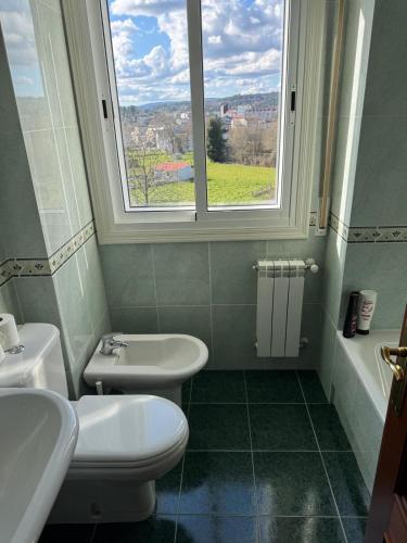 a bathroom with a sink and a toilet and a window at casa habana in Carballino