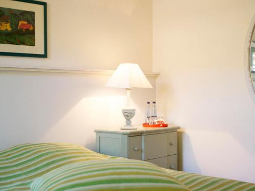 a bedroom with a bed and a lamp on a dresser at Landhaus Alte Schmiede in Niemegk