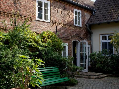 a green bench in front of a brick building at Landhaus Alte Schmiede in Niemegk