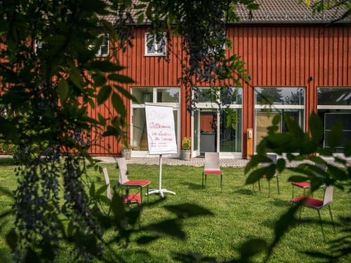 a group of chairs sitting in the grass in front of a building at Landhaus Alte Schmiede in Niemegk
