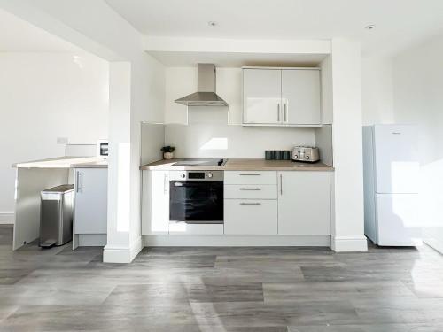 a white kitchen with white cabinets and appliances at Nelson Road - 3 Bed Terrace in Yarmouth in Great Yarmouth