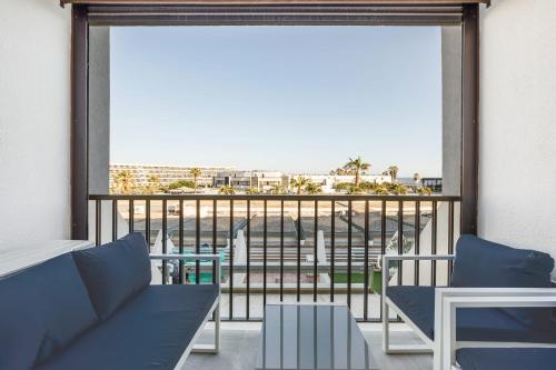 d'un balcon avec un canapé et une vue sur l'océan. dans l'établissement Naturiste Cap d'Agde Héliopolis F 49, au Cap d'Agde