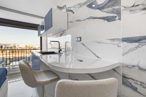 une cuisine avec un comptoir blanc et un évier dans l'établissement Naturiste Cap d'Agde Héliopolis F 49, au Cap d'Agde