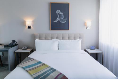 a bedroom with a white bed and a picture on the wall at Stanton House El Paso in El Paso