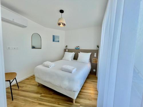 - une chambre blanche avec un lit blanc et une table dans l'établissement PGH N14 - 200m de la Plage avec Parking Privé, à La Grande Motte
