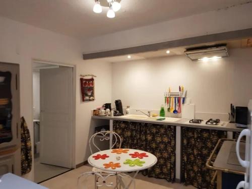 een keuken met een aanrecht en een tafel en een kruk bij Studio moderne à Montagnac-Montpezat - 32 m² tranquille in Montagnac