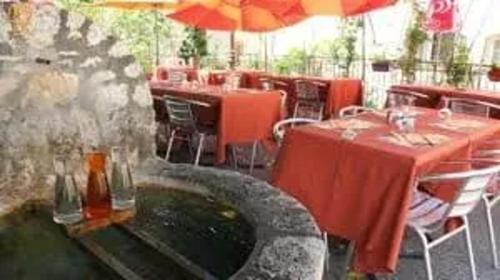 un restaurant avec des tables et des chaises et une fontaine dans l'établissement Appartement moderne à Gréolières, 26 m², vue saisissante, à Gréolières