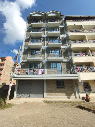 a tall apartment building with people on the balconies at Superhighway Inn -2 Minutes To SpurMall and Ashaki Resort 1800kes in Ruiru
