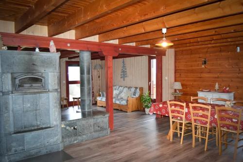 - un salon avec une cheminée, une table et des chaises dans l'établissement Chalet familial à Vagney + Jardin et Terrain de Bowling, à Vagney